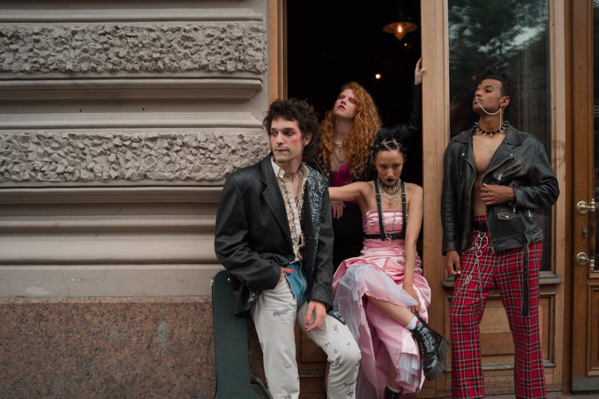 about-03 Four young adults in punk fashion pose against an urban backdrop, showcasing diversity and edgy style.