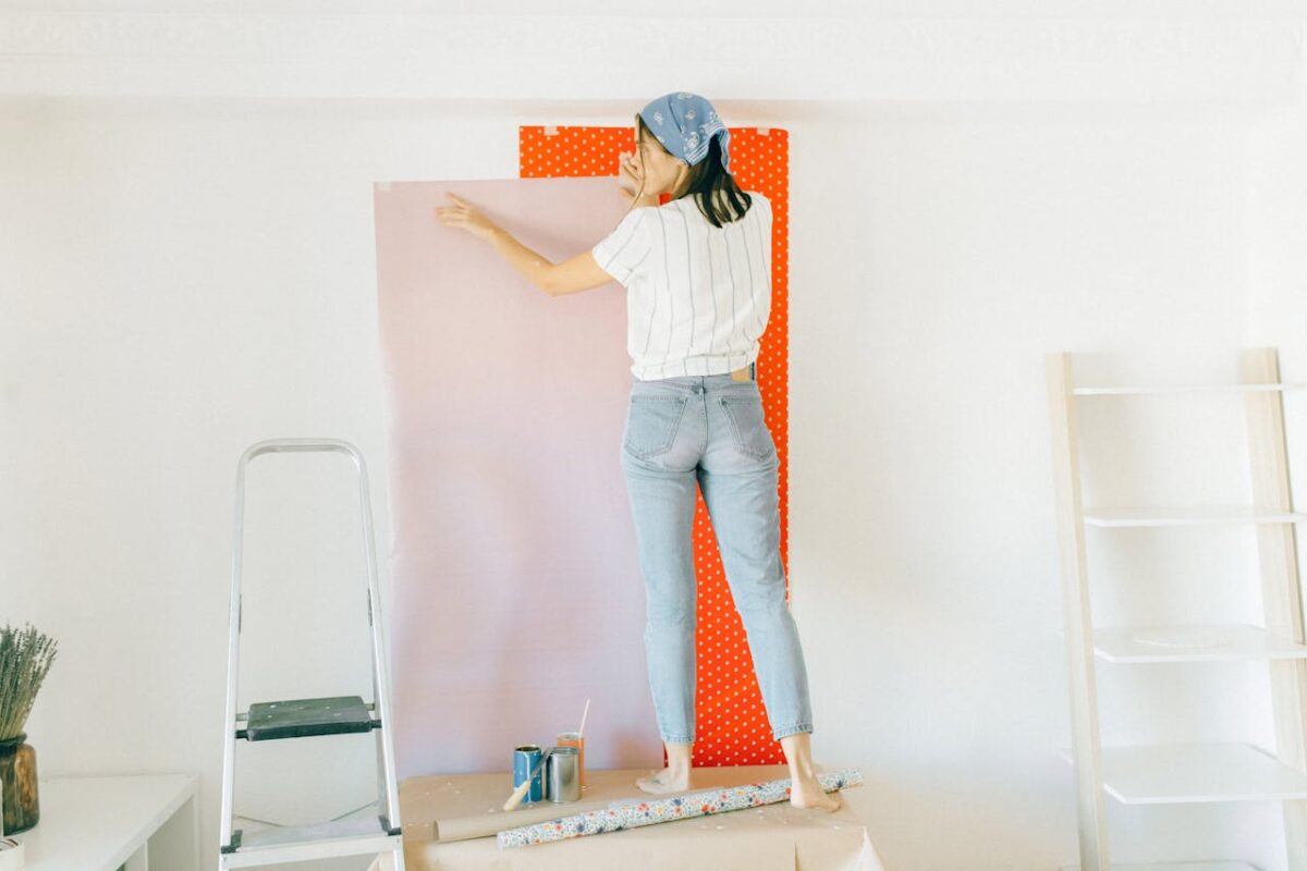 why-choose-us-01 A woman applying wallpaper on a wall for home renovation indoors.